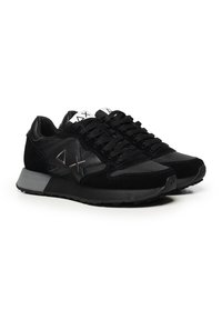 Sneakers atletici neri realizzati in suede e rete, con una superficie texturizzata, chiusura con lacci e suola in gomma grigia. Gli accenti includono un logo.