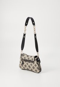 Béžová látková taška přes rameno s černým vzorem, zlatým kováním a odnímatelným černým popruhem. Má vnější zipovou kapsu a hladkou texturu.