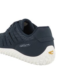 Zapatilla de deporte de color azul oscuro con una parte superior texturizada, diseño en capas y suela de goma blanca que presenta un patrón de tracción geométrica. Logo visible en el lateral.