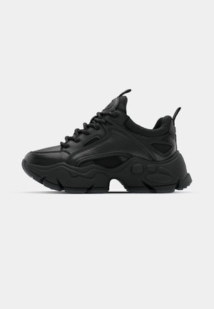 Sneaker nero con tomaia in pelle testurizzata, colletto imbottito, suola in gomma spessa con motivi distintivi e chiusura con lacci.