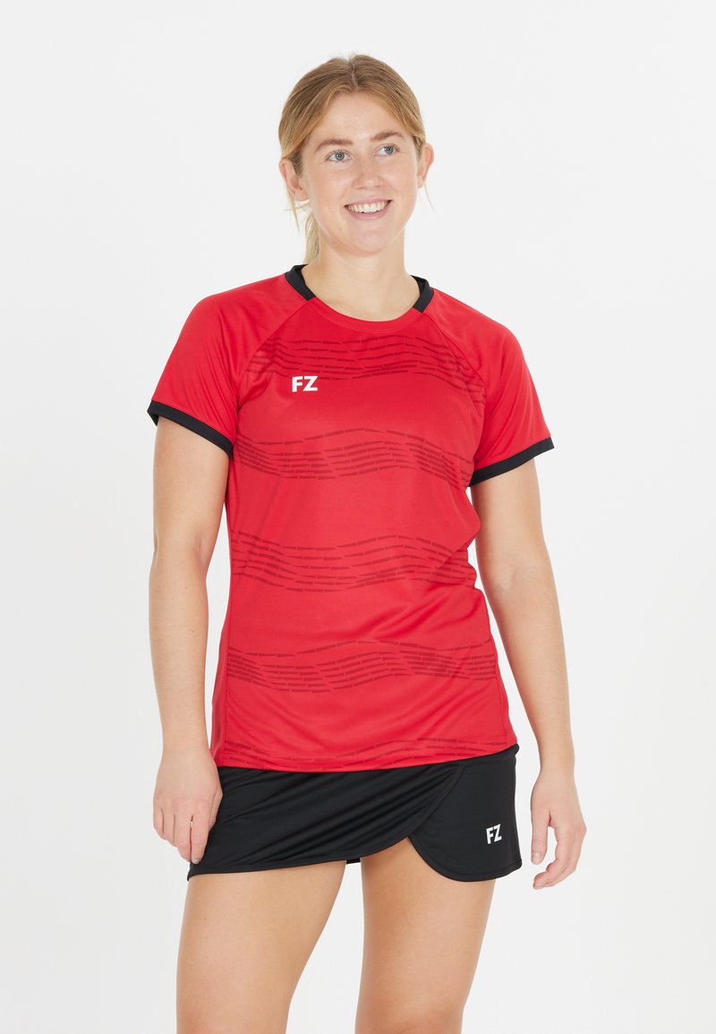 Punainen lyhythihainen urheilupaita, jossa on teksturoitu kuosi ja mustat yksityiskohdat, yhdistetty mustaan hameeseen. Kangas näyttää kevyeltä ja hengittävältä.