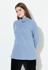 Långärmad polotröja i ljusblått med vita horisontella ränder. Mjuk tygkvalitet, lös passform och ribbad textur runt kragen.