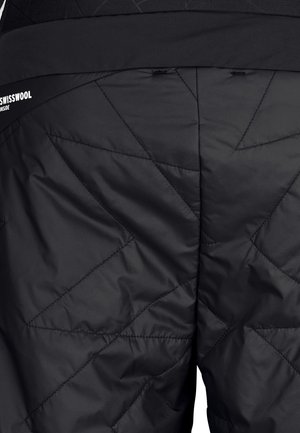 Black insulated pants featuring a quilted design with angular stitching and a smooth texture. Logo visible on the waistband.