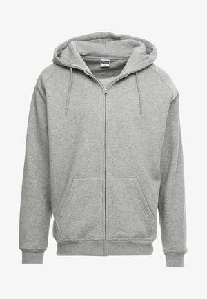 Grijze zip-up hoodie met een ruime capuchon, kangoeroe-zakken en geribbelde manchetten. De stof lijkt zacht en gestructureerd, geschikt voor casual wear.