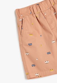 Pantalones cortos de algodón rosas con cintura elástica, que presentan patrones coloridos de pequeños vehículos por toda la prenda y bolsillos laterales.