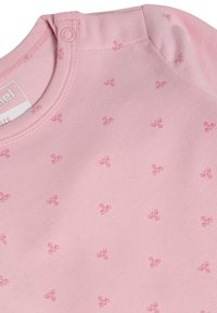 Ljusrosa babybodysuit i mjuk bomull, med små blommönster och tryckknappsstängning vid axeln för enkel påklädning.