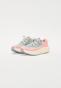 Des baskets grises et roses avec une semelle crème tachetée, un dessus texturé, une semelle en caoutchouc et des lacets vert clair. Présente un logo sur le côté.