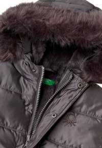 Pružná bunda tmavě šedé barvy s umělou kožešinou na kapuci. Obsahuje zipové zapínání a patkové knoflíky. Měkčená podšívka viditelná kolem límce.