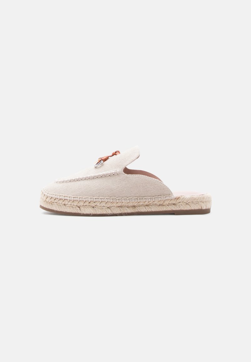 Mule espadrille beige à enfiler avec semelle en jute tressé et détail en métal marron sur le dessus, vue de profil sur fond blanc.