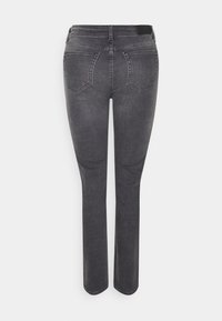 Vaqueros de mezclilla gris con un ajuste entallado, que presentan una cintura de tiro medio, dos bolsillos traseros y una textura suave. Sin adornos ni patrones visibles.