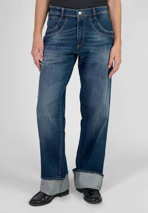 Jean en denim bleu avec une coupe droite, délavé, et des ourlets roulés. Il dispose de cinq poches et d'une fermeture à bouton en métal.