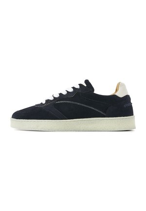 Navy suede sneaker with white laces and sole, beige heel tab, and zigzag stitching on the side.
