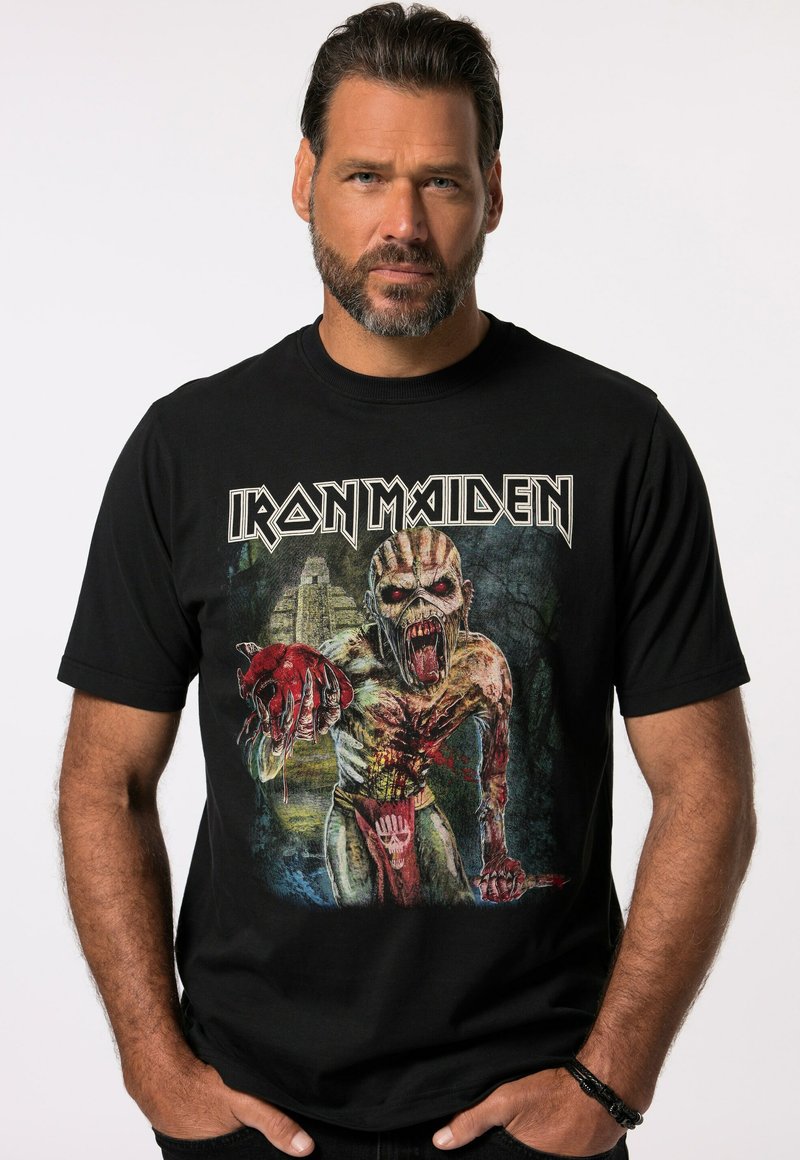 Sort bomulds t-shirt med et grafisk print af en zombie-lignende figur, med røde og grønne accenter, samt "Iron Maiden" tekst i stiliseret skrift.