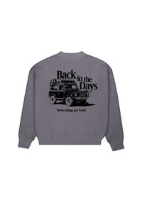 Pull gris avec un graphisme noir d'un véhicule tout-terrain vintage et les textes "Back in the Days" et "Before things got weird" au dos.
