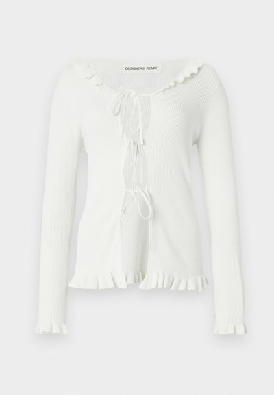 Λευκό μακρυμάνικο κορμάκι με ριμπ ύφασμα, διακοσμημένο με βολάν στη λαιμόκοψη και στο τελείωμα, με μπροστινό δέσιμο για ρυθμιζόμενη εφαρμογή. Μαλακή υφή.