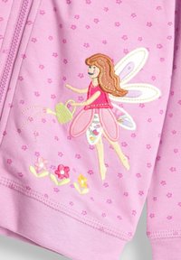 Rosa Kapuzenjacke mit einem Feen-Stickmotiv, die Blumen gießt; mit kleinen Blumenmustern, weichem Stoff und kontrastierenden Nähdetails.