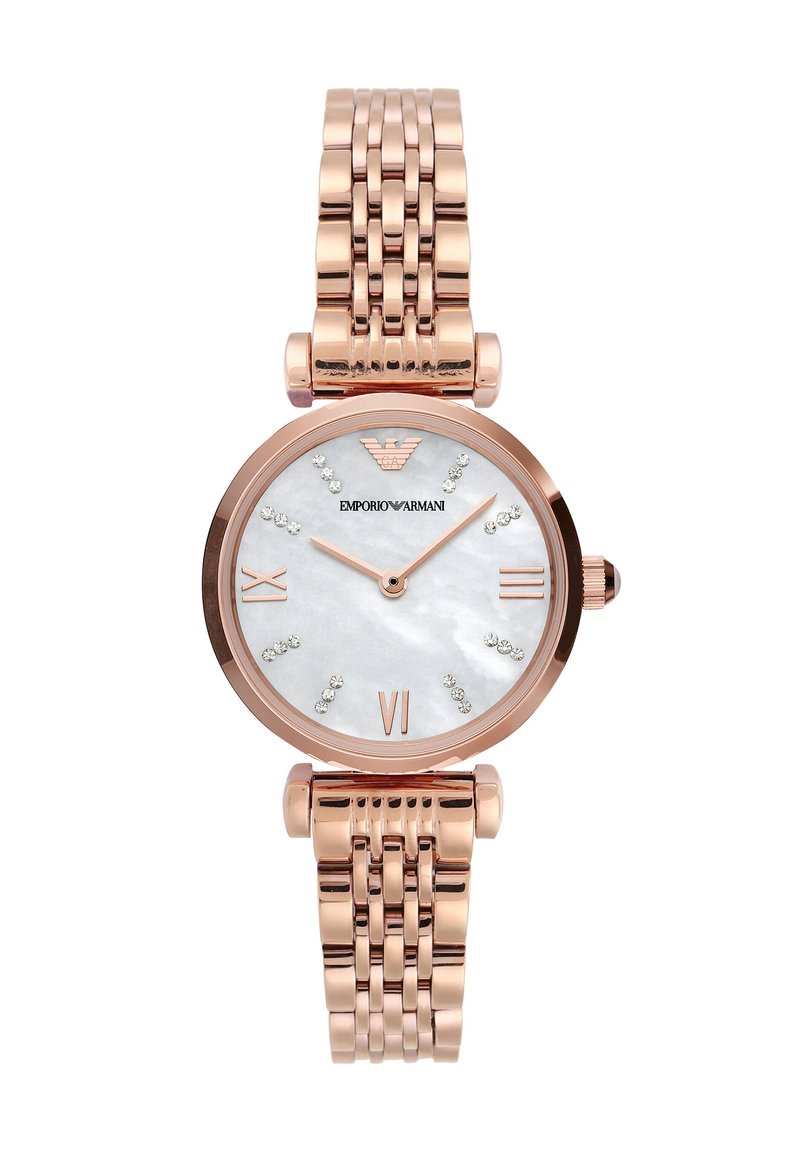 Růžově zlaté hodinky s kulatým pouzdrem, ciferníkem z perleti, římskými číslicemi a krystalovými akcenty. Obsahují spojený kovový náramek.