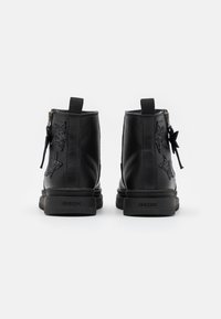 Mustat nahka ankle boots, joissa on kimaltelevia tähtikoristeita, sivussa vetoketju ja tukeva kumipohja, jossa on Geox-logo.