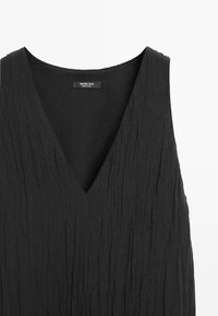 Schwarzes ärmelloses Kleid mit V-Ausschnitt und strukturierter Stoff, mit dem Etikett Massimo Dutti, hergestellt in China.