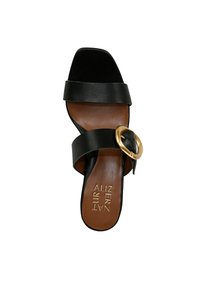 Sandalo slide in pelle nera con due ampie cinghie e un accento in metallo dorato a forma rotonda. Sottopiede marrone con dettagli del logo in rilievo.