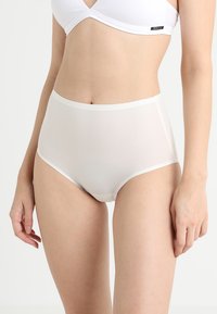 High-waisted white underwear made from smooth fabric, featuring a subtle sheen and contrasting elastic waistband. Simple, seamless design.