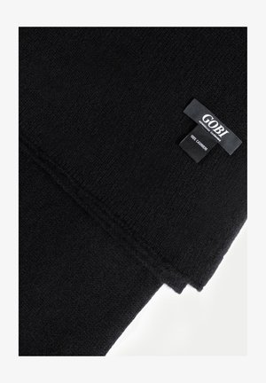 Schwarzer mongolischer Kaschmirschal mit gesteppten Kanten und einem Etikett mit der Aufschrift "GOBI 100% Kaschmir" auf weißem Hintergrund.