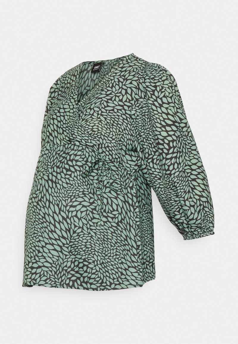 Robe portefeuille verte avec motif de feuilles noires, manches longues bouffantes, et ceinture nouée à la taille.