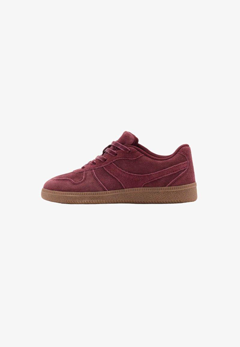 Baskets basses en daim rouge foncé avec des lacets assortis et une semelle en caoutchouc marron, montrées de profil sur fond blanc.