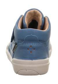Scarpa alta in pelle blu con interno color cuoio, cinturino in velcro e suola bianca. Presenta piccoli fori di ventilazione e un'etichetta con il marchio sul lato.