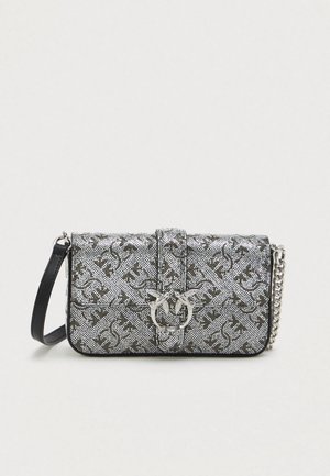 Bolsa tecida prateada com formato retangular, apresentando uma alça preta, ferragens metálicas e um padrão em relevo na superfície.