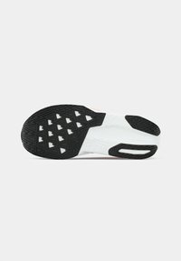 Black and white athletic shoe sole featuring a textured rubber pattern with triangular cutouts and a sleek design.