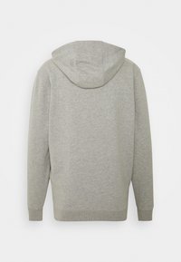 Sudadera gris con una tela suave y texturizada. Cuenta con un bolsillo tipo canguro, puños acanalados y una capucha ajustable con cordón. Vista trasera.