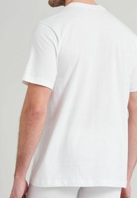 White cotton T-shirt with short sleeves, solid color, crew neckline, relaxed fit, smooth texture, showing the back view with no patterns.