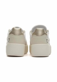 Sneaker bianche con upper in pelle liscia e un accento metallico dorato sul tallone. Sole in gomma bianca chunky con dettagli testurizzati.
