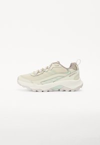 Helle beige Sportschuh mit Mesh- und Synthetik-Obermaterial, dicker weißer Sohle und dezenten mintgrünen Akzenten. Verfügt über Schnürsenkel und eine Zuglasche.