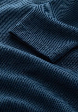 Marineblauer gerippter Stoff mit einer weichen Textur, der feine vertikale Streifen und ein umgeschlagenes Ärmel-Detail aufweist.