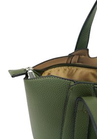 Groene leren handtas met een gestructureerd oppervlak, zwarte accenten en een ritsopening die een tan interieur onthult. Twee handvatten aan de bovenkant zijn zichtbaar.