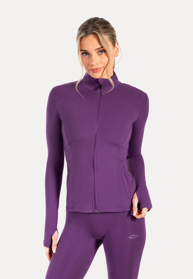 Chaqueta atlética de manga larga morada con cuello alto, cremallera frontal y bolsillos laterales. Tela suave y elástica, silueta ajustada.
