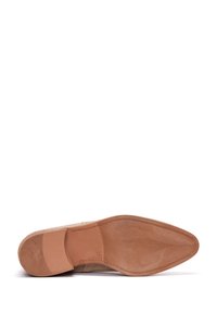 Semelle de chaussure en cuir beige avec une texture lisse et un bout pointu. Présente un léger talon et des coutures le long du bord.
