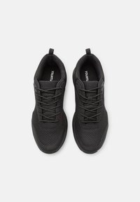Black athletic shoes with a mesh upper, reinforced toe, laces, and pull tabs. The sole is textured for grip, designed for comfort.