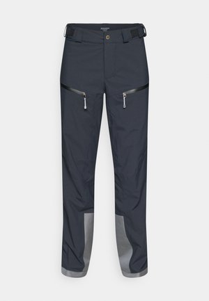 Dunkelgraue Outdoor-Hose aus robustem Stoff, mit zwei Reißverschlusstaschen und reflektierenden Akzenten an den Bündchen für bessere Sichtbarkeit.