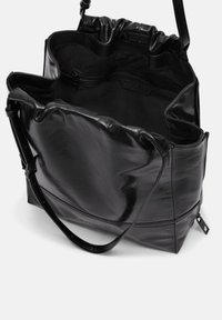 Schwarze Ledertasche mit einem geräumigen, gerafften Oberteil. Verfügt über eine glatte Textur, eine Reißverschlusstasche im Inneren und einen verstellbaren Schultergurt.
