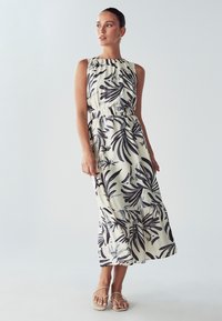 Maxi obleka brez rokavov iz lahkega materiala z vanilijevo osnovo in boldnim črnim listnatim vzorcem, z elastičnim pasom in plastenjem na robu.