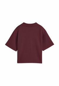 Polo a maniche corte bordeaux con colletto strutturato e tessuto testurizzato, caratterizzato da una vestibilità rilassata e linee pulite.