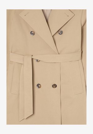 Cappotto beige doppiopetto con cintura, realizzato in tessuto morbido, dotato di grandi bottoni e colletto a pistagna, con tasche laterali.