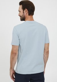 Lyseblå kortermet t-skjorte med rund hals, laget av glatt stoff, med et enkelt design uten fremtredende mønstre eller detaljer.