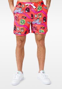 Red swim shorts featuring a vibrant, cartoonish print with various colorful characters and patterns. Includes a white drawstring and side pockets.