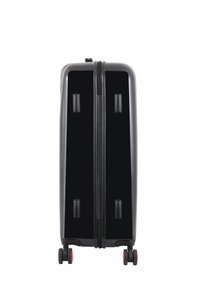 Black hard-shell suitcase with dual zippers, two top handles, four wheels, and red accents on the wheels. Smooth, glossy finish.