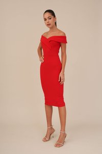 Abito rosso off-the-shoulder con corpino strutturato, silhouette aderente e orlo a ginocchio. Indossato con sandali alti con cinturini dorati.