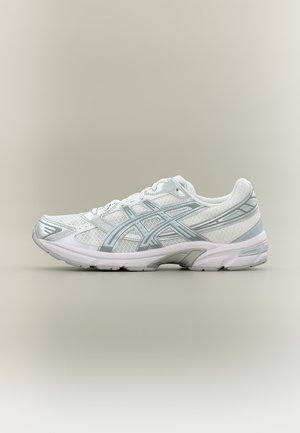 Chaussure de running basse blanche et argentée avec tissu en mesh, logo Asics, semelle coussinée et design à lacets sur fond neutre.